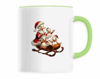 Op de afbeelding: Witte keramische mok met een groene handgreep en rand. De mok heeft een cartoonillustratie van eenden in kerstmanoutfits die op een houten slee rijden. De eenden dragen rode kerstmutsen en jassen, perfect voor de feestdagen.