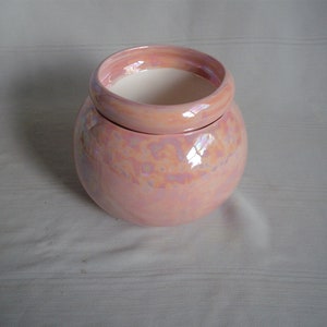 Op de afbeelding: Een roze keramische plantenpot met een iriserende glazuur. De pot heeft een ronde vorm en een brede opening.