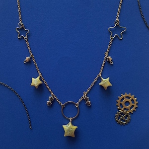 collana artigianale oro con stelle di carta e ciondoli.