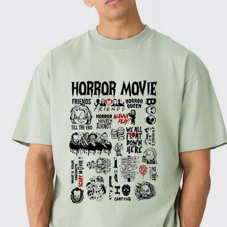 Peut inclure: T-shirt vert clair avec un motif noir. Le motif pr&eacute;sente les mots "HORROR MOVIE" et diverses r&eacute;f&eacute;rences de films d'horreur. Le motif comprend des images et du texte comme "FRIENDS", "HORROR QUEEN" et "WE ALL FLOAT DOWN HERE".