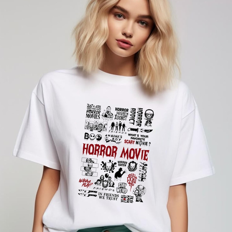 Peut inclure: T-shirt blanc avec un motif noir sur le th&egrave;me de l'horreur. Le motif comprend les mots "HORROR MOVIE" en rouge, ainsi que diverses images et phrases li&eacute;es &agrave; l'horreur telles que "HORROR ADDICT" et "Wanna Play?"