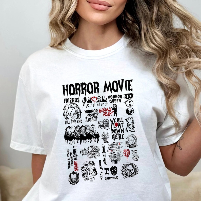Peut inclure: T-shirt blanc avec un motif graphique noir repr&eacute;sentant les mots "HORROR MOVIE" et diverses images et phrases sur le th&egrave;me des films d'horreur. Le motif comprend des images de personnages et des citations de films d'horreur populaires.