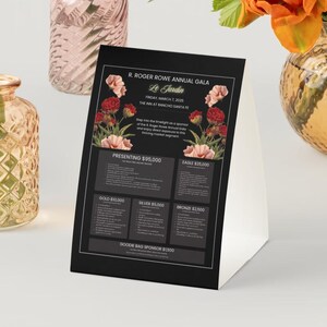 May include: A black and white table tent with floral illustrations and text that reads "R. Roger Rowe Annual Gala", "Le Jardin", "Friday, March 1, 2020", "The Inn at Rancho Santa Fe", "Presenting $95,000", "Eagle $25,000", "Gold $10,000", "Silver $5,000", "Bronze $2,500", and "Goodie Bag Sponsor $1,000".