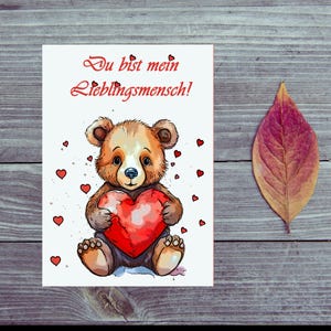 Carte postale. Ours d'amour avec le coeur en main.