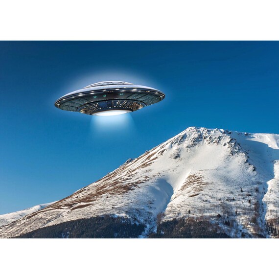 Postcard. UFO over snowy mountain peaks