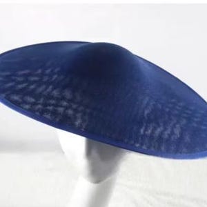 May include: A navy blue, wide-brimmed hat with a mesh overlay. The hat has a rounded crown and a broad, flat brim. The brim is trimmed with a solid navy blue band. The hat is displayed on a white mannequin head.