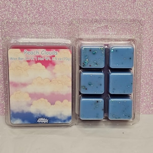 May include: A package of six blue wax melts with glitter, labeled "Peach Clouds" Wax Bar 3.0 fl. | Net Wt. 2.5 oz. (70g).