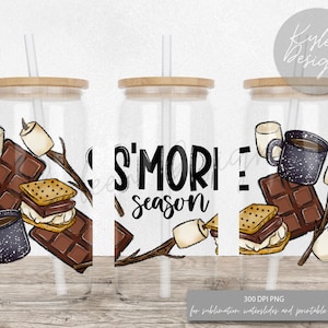 Może przedstawiać: Przezroczysty szklany kubek z bambusową pokrywką i słomką. Kubek posiada wzór "S'Mores Season" z ilustracjami pianek marshmallow, czekolady, krakersów Graham i kubków do kawy. Wzór jest nadrukowany na szkle.