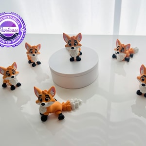 May include: Six small orange and white fox figurines with large eyes and black paws. One fox stands on a white circular platform, while the other five are arranged around it. Each fox features a bushy tail and a white chest patch, with a purple logo.