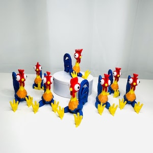 May include: Seven blue, yellow, and red rooster figurines with large eyes. The roosters are sitting on a white surface.