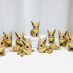 May include: Nine brown Eevee Pokemon figurines with different poses. The figurines are made of plastic and have a soft, fuzzy texture.