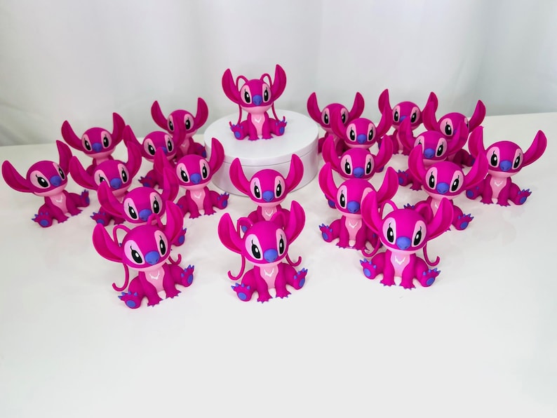 May include: A group of 15 pink Stitch figurines with blue accents. The Stitch figurines are arranged in a circle on a white surface.