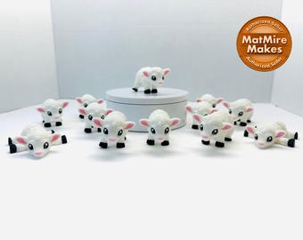 Puede incluir: Un grupo de 10 figuritas de ovejas blancas con pezuñas negras y narices rosas. Las ovejas están en varias poses, incluyendo de pie, acostadas y mirando hacia arriba. Las figuritas están hechas de un material liso y blanco y miden aproximadamente 5 cm de alto.