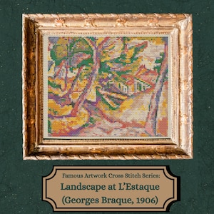May include: A framed cross-stitch of Georges Braque's "Landscape at L'Estaque" from 1906. The artwork features a colorful landscape with trees and buildings, framed in a gold-colored ornate frame. The text on the label reads "Famous Artwork Cross Stitch Series: Landscape at L'Estaque (Georges Braque, 1906)".