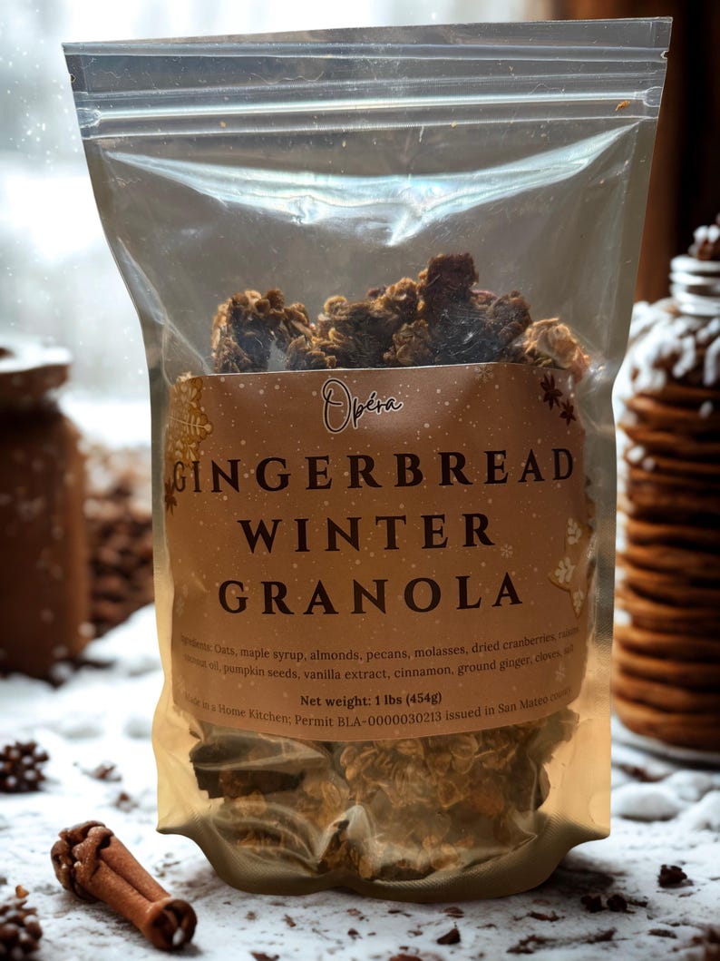 K&ouml;nnte beinhalten: Ein transparenter Beutel mit Lebkuchen-Winter-Granola. Auf dem Etikett steht "Op&eacute;ra GINGERBREAD WINTER GRANOLA". Zutaten sind Haferflocken, Ahornsirup, Mandeln und Pekann&uuml;sse. Nettogewicht: 454 g.