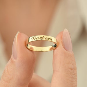 May include: A gold band ring with the name "Barbara" engraved on it.