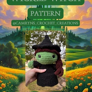 May include: Crocheted Wicked Witch doll with a black dress, hat, and red hair. The doll has a green face and is held in front of a landscape painting. Text on the image reads "WICKED WITCH PATTERN" and "@CAMRYNS_CROCHET_CREATIONS."