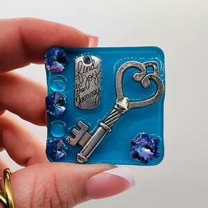 May include: A set of three ceramic mugs with a speckled, matte finish. The mugs are in shades of cream, light gray, and dark gray. Each mug has a simple, minimalist design and a rounded handle. Perfect for coffee or tea.