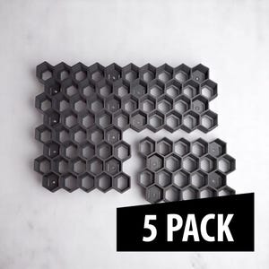 May include: Five dark gray honeycomb-shaped molds, arranged on a white surface. The molds are made of plastic and are designed to interlock. The image includes a black banner with the text "5 PACK".