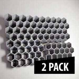 May include: Two gray, honeycomb-shaped wall organizers. Each organizer is composed of numerous hexagonal cells. The product is labeled "2 PACK" in white text on a black rectangular background.