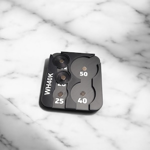 May include: Black plastic coin holder with four compartments labeled "WH40K", "25", "40", and "50".