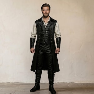 May include: A long black leather coat worn over a black vest with a lace-up front, a light beige long-sleeved shirt, black trousers, and black leather boots. The coat features a wide collar and metallic buttons, while the sleeves have black cuffs.