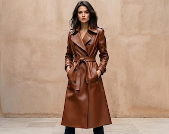 May include: A long, double-breasted trench coat in a rich brown color, featuring a wide collar, long sleeves with buckled cuffs, and a matching tie belt at the waist. The coat has dark buttons down the front and two side pockets.