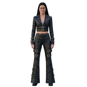 May include: A black leather two-piece set consisting of a cropped blazer and flared trousers. Both pieces feature silver-toned metal studs and multiple adjustable buckle straps on the sleeves, waist, and legs, creating a structured appearance.