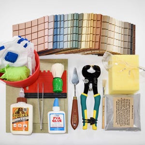 May include: A selection of tiling tools and materials, including a red bowl with gloves, tile samples in various colours, a sponge, safety glasses, and bottles of glue. Also included are a brush, nippers, and a trowel.