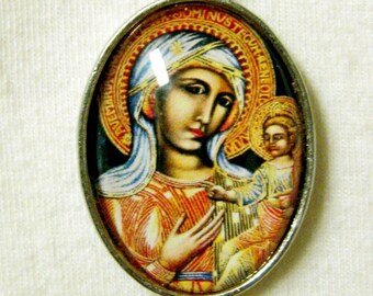 Puede incluir: Collar de cadena de plata con un colgante ovalado que presenta una imagen colorida de la Virgen María y el niño Jesús. El colgante tiene el texto "DOMINUS NOSTER" alrededor del borde.