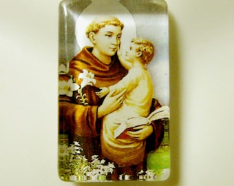 May include: A silver chain necklace with a clear glass pendant featuring a colorful image of Saint Anthony of Padua holding a baby Jesus.