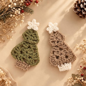 May include: Two crocheted Christmas tree ornaments, one in olive green and one in tan, each topped with a white crocheted star. The green tree has a tan base, while the tan tree has a white base. Both feature an open, airy stitch pattern.