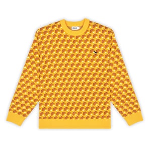 May include: A long-sleeve crewneck sweater featuring a repeating yellow and orange honeycomb pattern. The knit garment has a solid yellow ribbed collar, cuffs, and hem. A small black dinosaur silhouette is embroidered on the upper right chest.