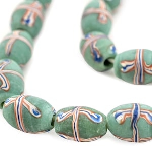 May include: A strand of green glass beads with white, blue, and orange stripes. The beads are oval shaped and have a glossy finish.