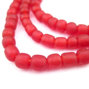 May include: A strand of red glass beads. The beads are round and have a matte finish.