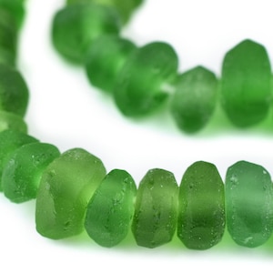 May include: A strand of green glass beads, each bead is slightly irregular in shape and has a frosted finish.