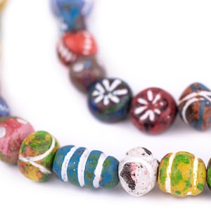 May include: A colourful beaded necklace with various patterns and designs. The beads are made of wood and painted in bright colours, including red, blue, green, yellow, and white.