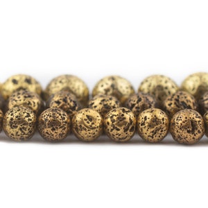 May include: A row of round, gold-colored beads with a textured, speckled surface.