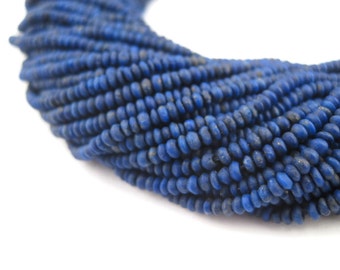 May include: A strand of deep blue lapis lazuli beads, each bead is a slightly irregular oval shape.
