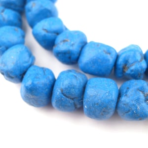 May include: A strand of blue turquoise beads, each bead is a slightly irregular cube shape.