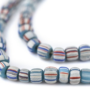 Peut inclure: Un collier de petites perles en verre en forme de tonneau, ornées de rayures verticales répétitives bleu clair, blanches, bleu foncé et orange. Les perles sont disposées sur deux rangées, présentant une forme cylindrique et un fini mat.