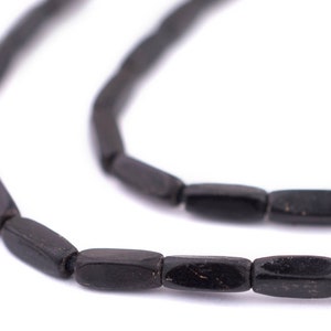 May include: A strand of black, rectangular beads. The beads are made of a smooth, polished material.