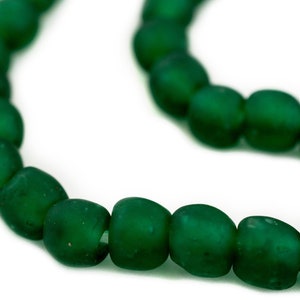 May include: A strand of dark green glass beads. The beads are round and have a matte finish.