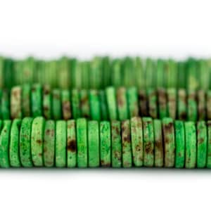 May include: Close-up of strands of green, disc-shaped beads. The beads have a natural, earthy appearance with variations in color, including brown spots. The beads are arranged in rows, suggesting they are for jewelry making or crafting.