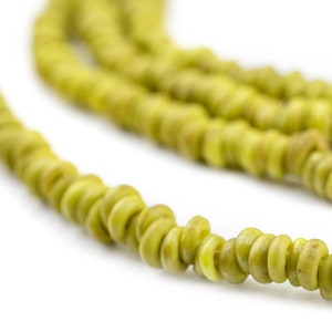 May include: A strand of green, round, ceramic beads. The beads are strung together to form a necklace or bracelet.