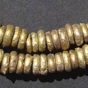 May include: A strand of gold-toned metal beads, each bead is round and has a textured surface.