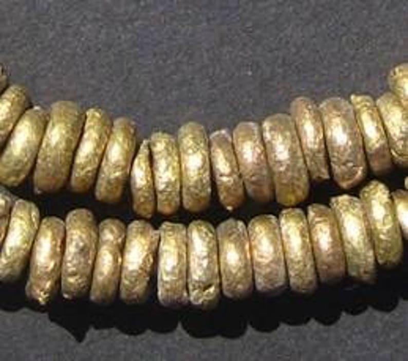 May include: A strand of gold-toned metal beads, each bead is round and has a textured surface.