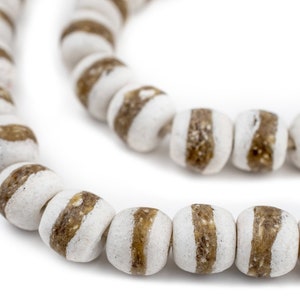 May include: A strand of white and brown glass beads. The beads are round and have a striped pattern.