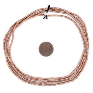 May include: A strand of copper-colored beads, approximately the size of a US penny, arranged in a circle.