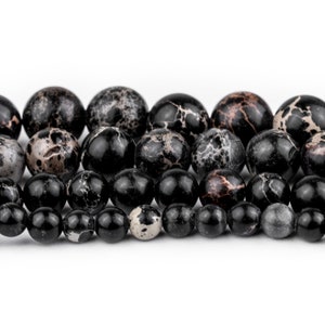 May include: A strand of black and white speckled beads. The beads are round and have a smooth, polished finish.